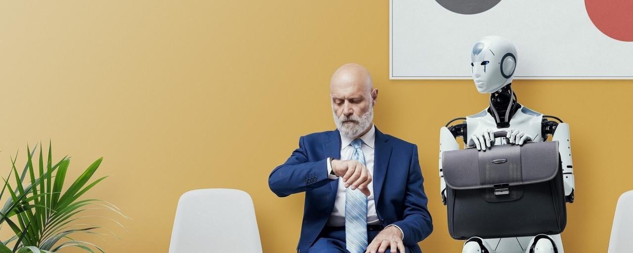worker in a suit sitting next to a robot